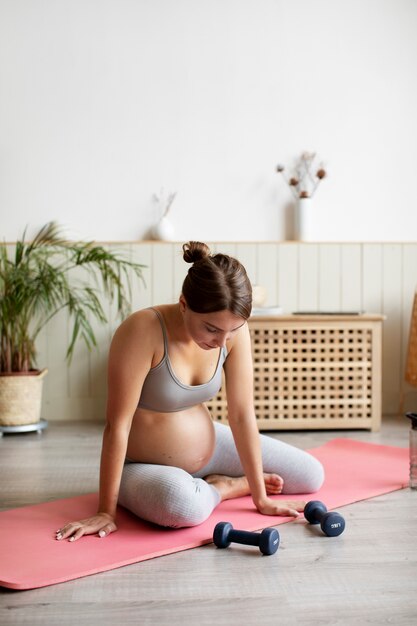 Mulher grávida treinando em casa