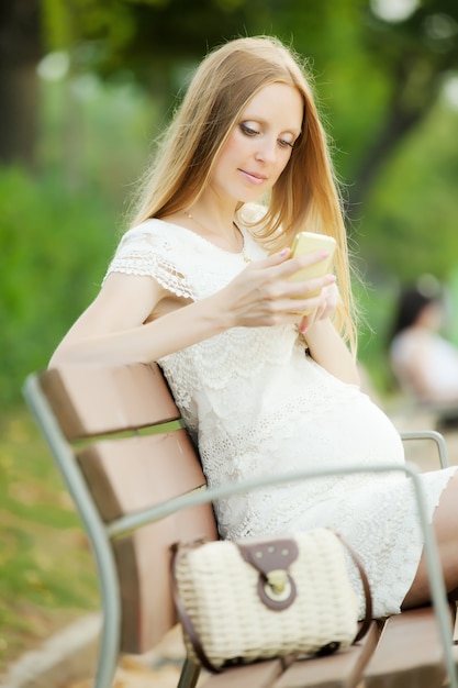 Mulher grávida usando celular