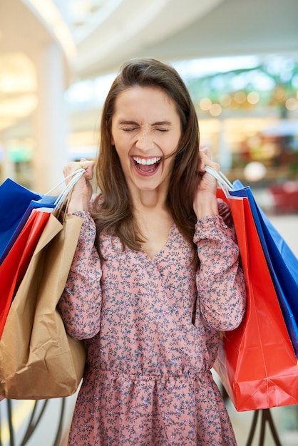 Mulher gritando com sacolas de compras