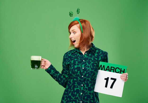 Mulher gritando com uma caneca cheia de cerveja e calendário