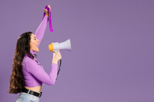 Mulher gritando no megafone em pé lateralmente com espaço de cópia