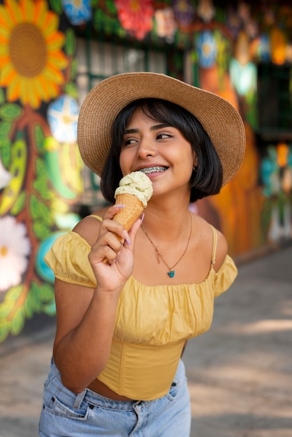 Foto grátis mulher hispânica de tiro médio comendo sorvete