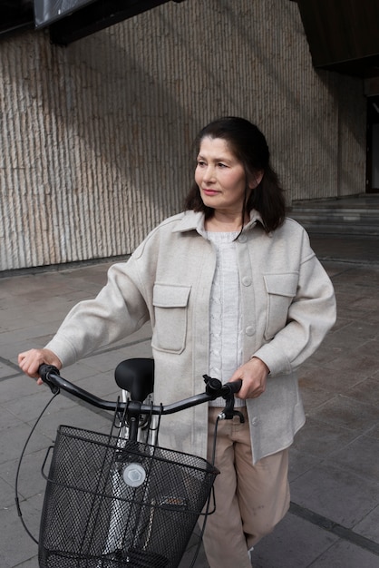 Foto grátis mulher idosa andando com sua bicicleta