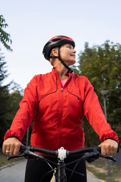 Mulher idosa andando de bicicleta ao ar livre