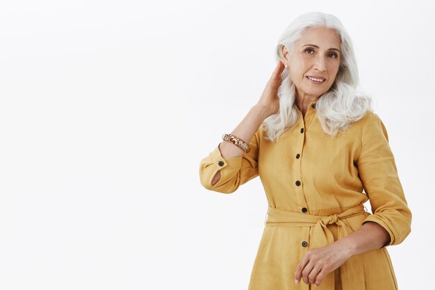 Mulher idosa bonita e elegante parecendo satisfeita com o corte de cabelo