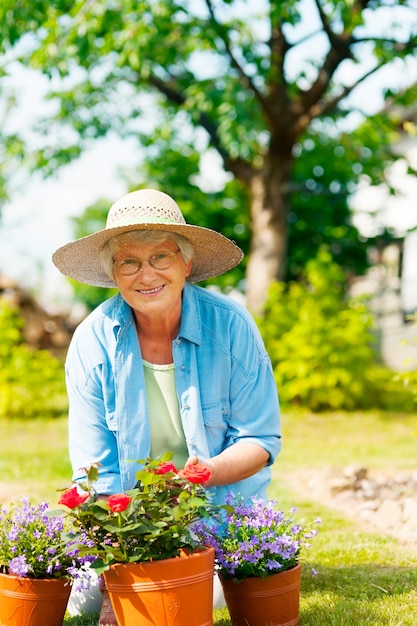 Mulher idosa com flores no jardim