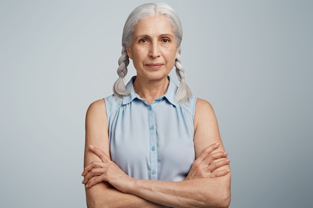 Mulher idosa com rabo de cavalo vestida com blusa azul