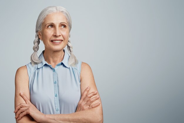 Mulher idosa com rabo de cavalo vestida com blusa azul