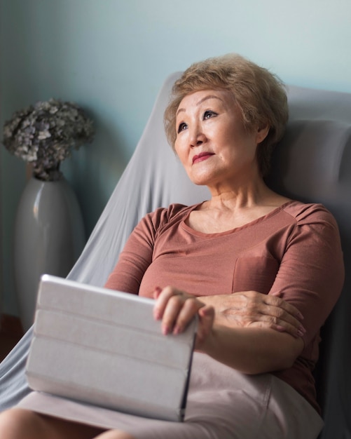 Mulher idosa com tiro médio com tablet