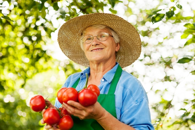 Mulher idosa com tomates