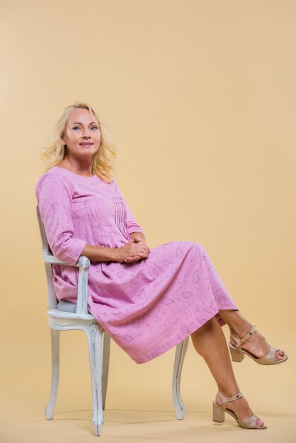 Mulher idosa sentada em uma cadeira vintage