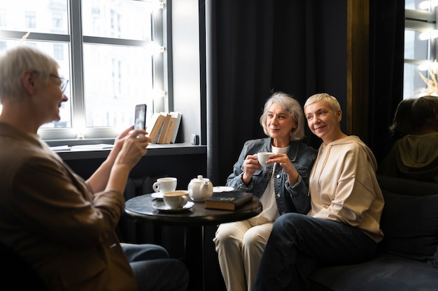 Mulher idosa tirando foto de amigos durante uma reunião