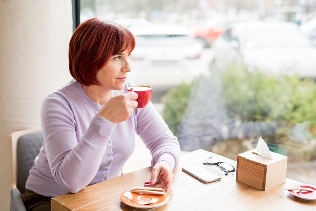 Mulher idosa tomando café