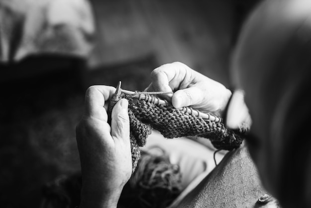 Mulher idosa tricotando em casa