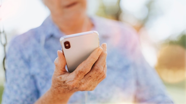 Mulher idosa usando o telefone em um parque