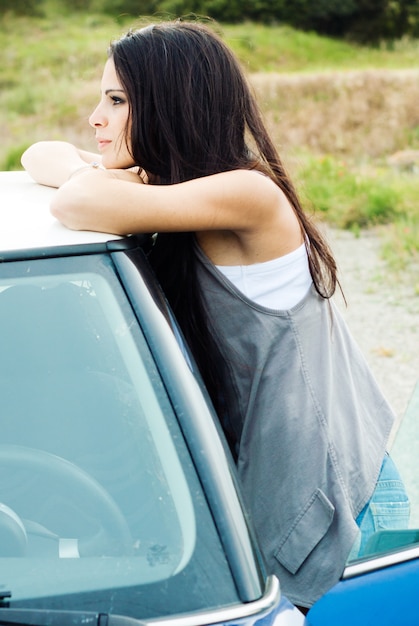 Foto grátis mulher inclinada sobre um carro