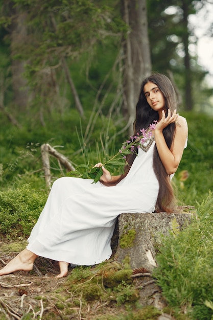 Mulher indiana com cabelo comprido. Senhora de vestido azul. Menina com natureza intocada.