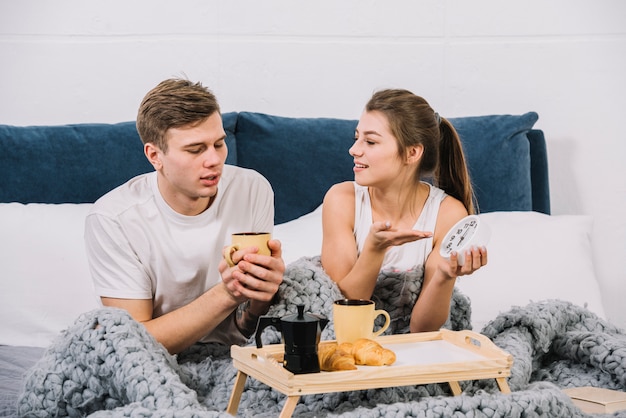 Foto grátis mulher insatisfeita mostrando no relógio na cama