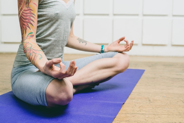 Mulher irreconhecível meditando em casa