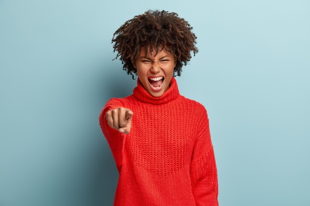 Foto grátis mulher irritada emocionalmente estrita ficando furiosa, aponta para a câmera com raiva e indignação e culpa você