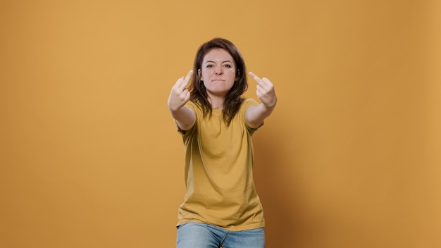 Foto grátis mulher irritada mostrando o gesto obsceno do dedo médio com problema de atitude agressiva sendo rude e desrespeitoso no estúdio. pessoa infeliz tendo conflito mostrando agressão e raiva.