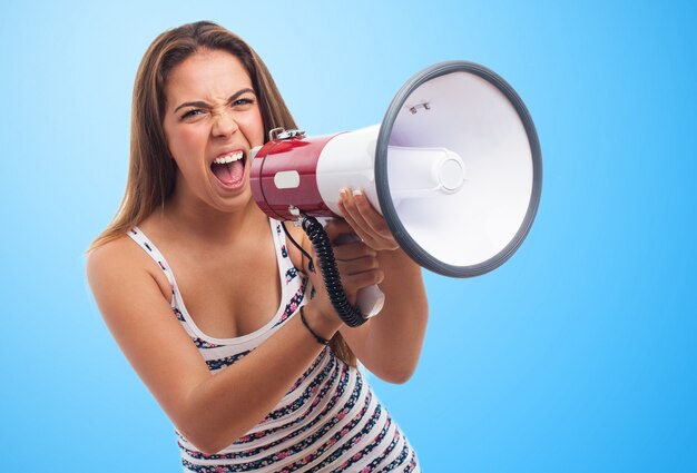 Mulher irritada que grita através de um megafone