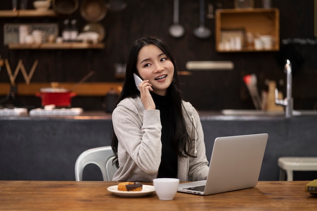 Foto grátis mulher japonesa falando em seu smartphone enquanto trabalhava em um restaurante