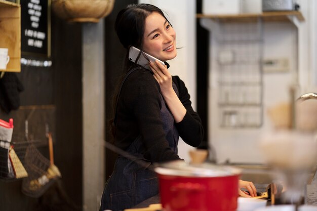 Mulher japonesa falando no smartphone em um restaurante