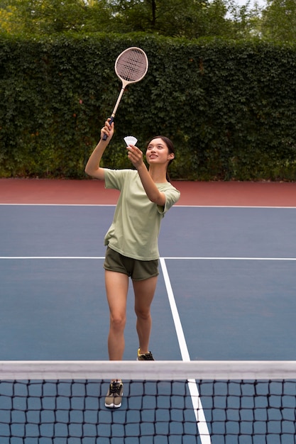 Mulher jogando badminton tiro completo