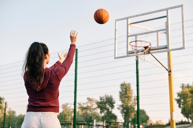 Mulher jogando basquete sozinha com espaço de cópia