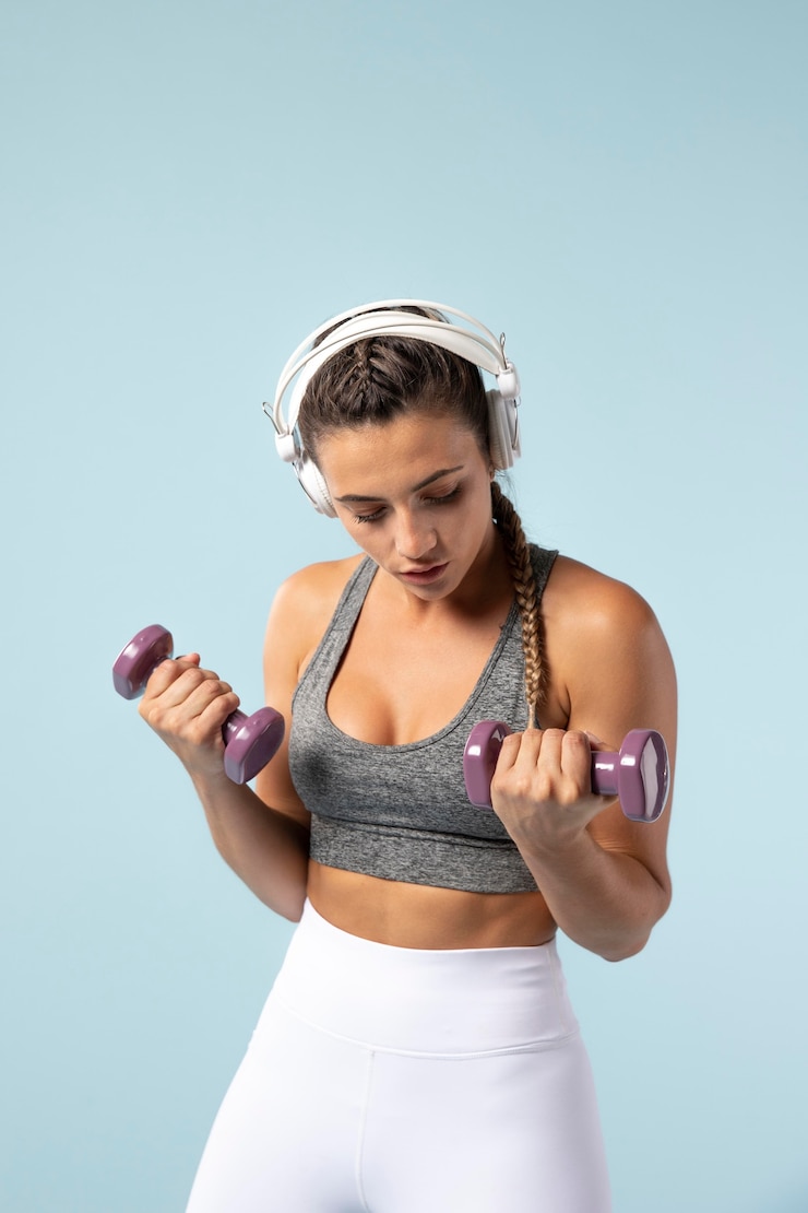Foto grátis mulher jovem a fazer exercícios com os fones de ouvido.