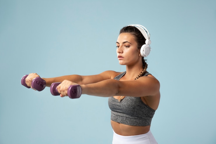 Foto grátis mulher jovem a fazer exercícios com os fones de ouvido.