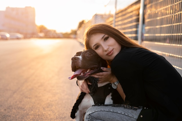 Foto grátis mulher jovem abraçando seu pitbull