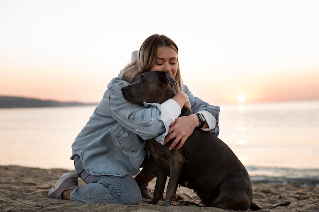 Foto grátis mulher jovem abraçando seu pitbull