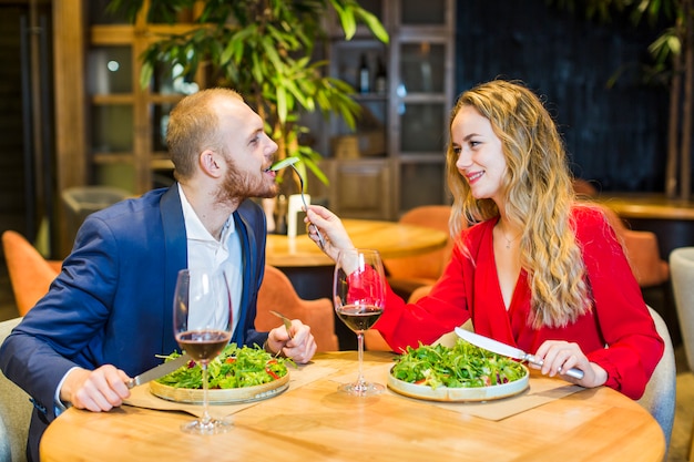 Mulher jovem, alimentação, homem, com, salada, em, restaurante