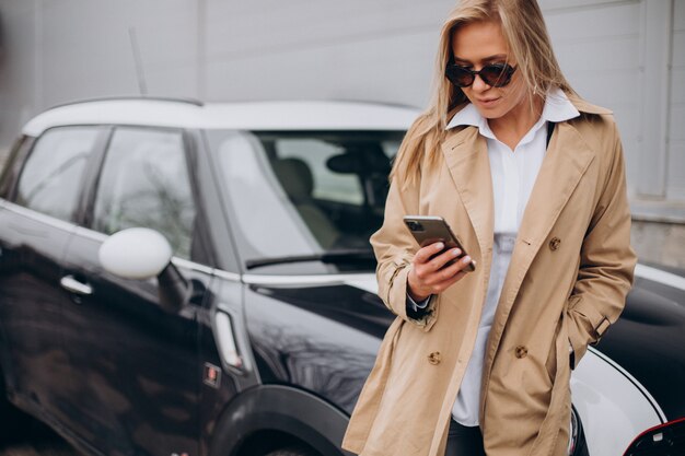 Mulher jovem ao lado do carro