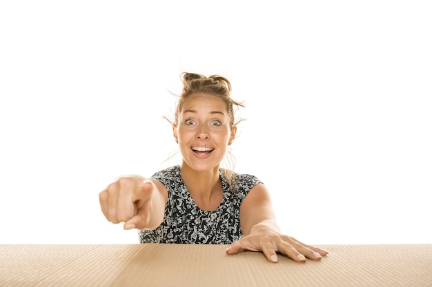 Foto grátis mulher jovem apontando para a frente em uma mesa de madeira