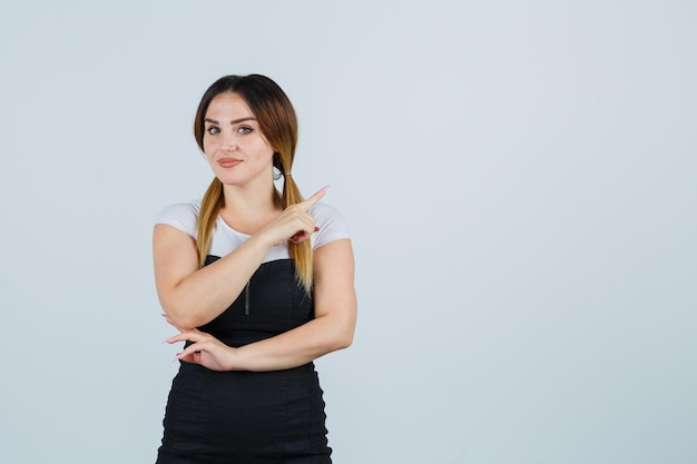 Mulher jovem apontando para o canto superior direito