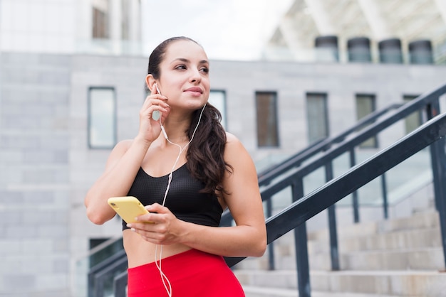 Mulher jovem atleta com um smartphone