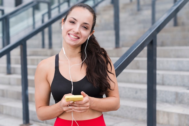 Mulher jovem atleta com um smartphone