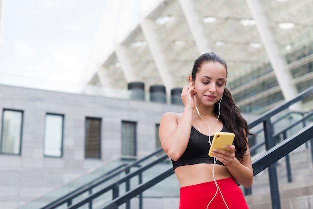 Mulher jovem atleta com um smartphone