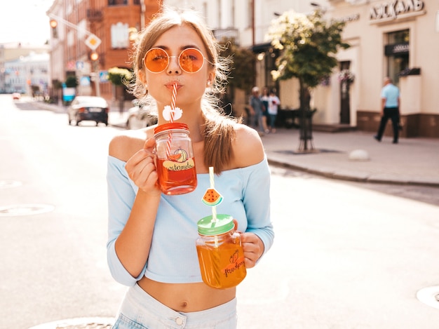 Mulher jovem bonita sorridente hipster em óculos de sol.