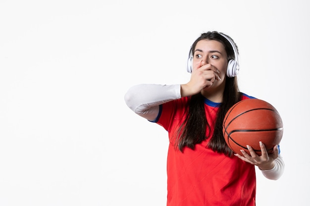 Mulher jovem chocada com vista frontal em roupas esportivas e basquete