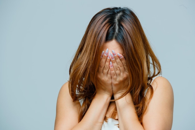 Foto grátis mulher jovem cobrindo o rosto com as mãos e parecendo triste