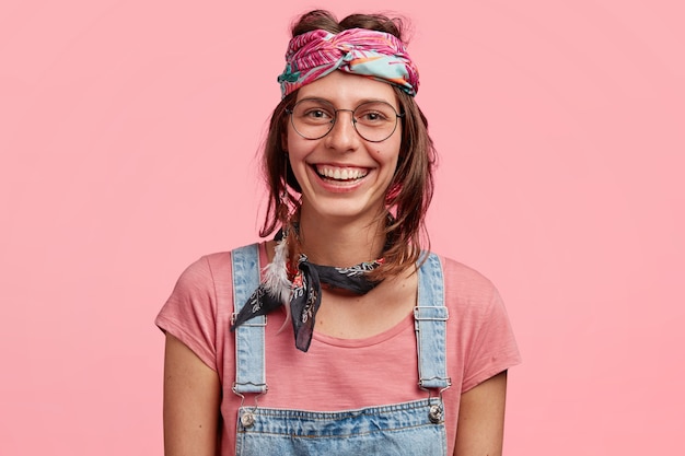 Mulher jovem com bandana colorida e macacão jeans