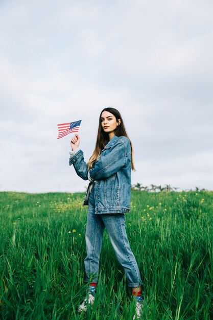 Mulher jovem, com, bandeira americana, ficar, em, campo