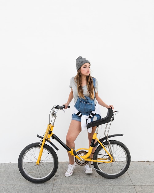 Foto grátis mulher jovem, com, bicicleta, ficar, ligado, calçada