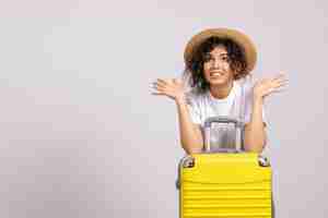 Foto grátis mulher jovem com bolsa amarela se preparando para uma viagem no fundo branco cor do sol viagem férias avião voo turístico