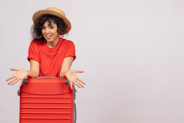 Foto grátis mulher jovem com bolsa vermelha se preparando para a viagem no fundo branco cor do vôo descanso sol viagem turística férias