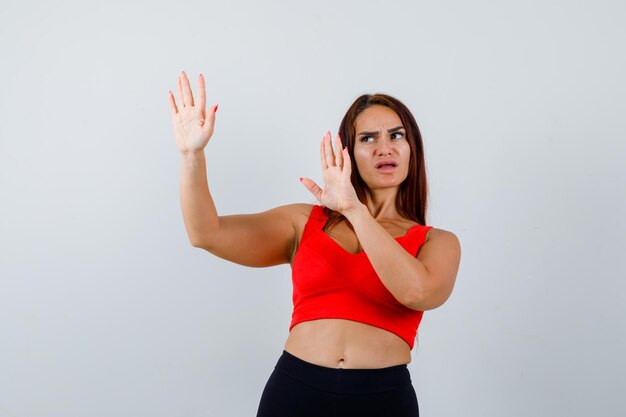 Mulher jovem com cabelo comprido e uma regata laranja